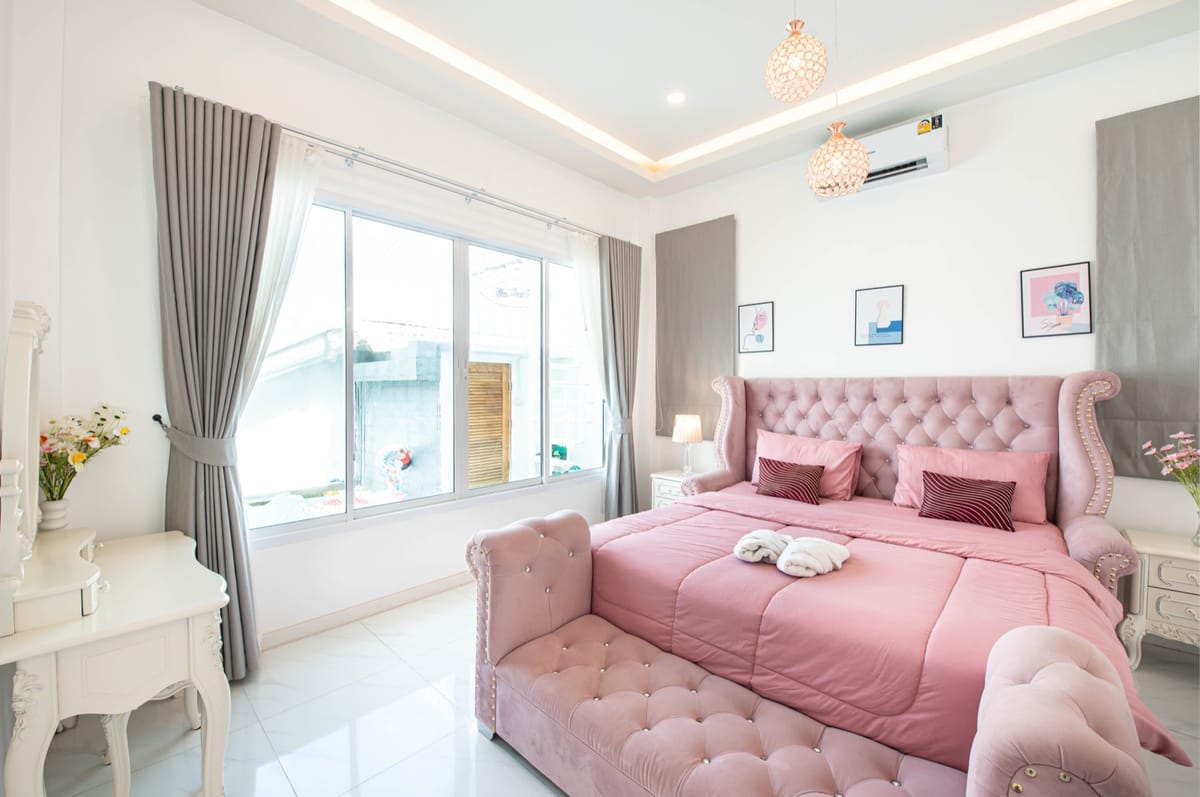 Pink bedroom with a king bed at Mina Pool Villa